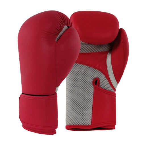 Woman hitting heavy punching bag while wearing red boxing gloves.